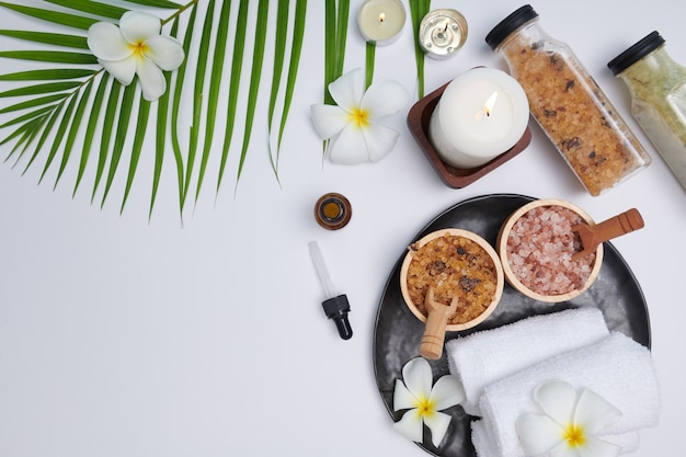 Spa concept. beauty and fashion concept with spa set. perfumed\
flowers water. relaxation and zen, spa setting flat lay with bowl,\
bath salt and flowers, towel and natural soap. top view.