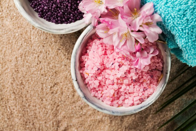 Spa Concept. Closeup of beautiful Spa Products - Spa Salt, Towels and Flowers. Horizontal.