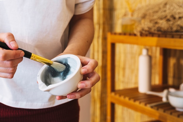 Foto gratuita concetto della stazione termale con la donna che mescola crema facciale