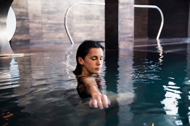 Foto gratuita concetto della stazione termale con la donna che si distende in acqua
