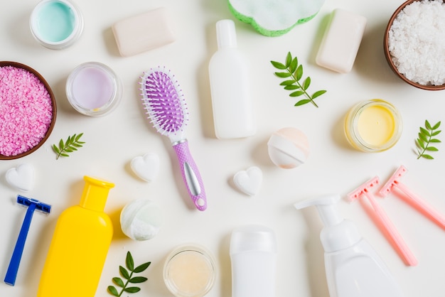 Spa cosmetics products with razor and hairbrush on white background