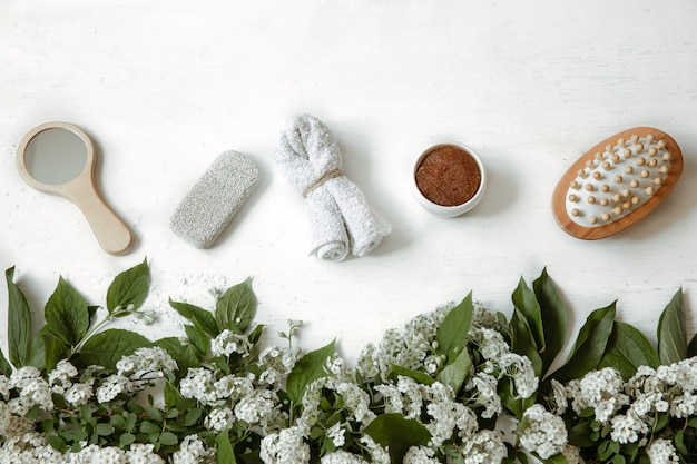 Spa flat lay composition with bath accessories, health and beauty products with fresh flowers.