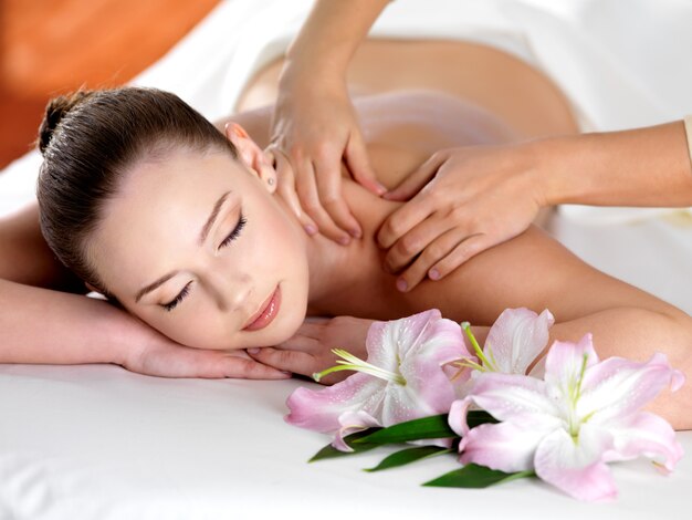 Spa massage on a shoulder for young beautiful woman in  beauty salon