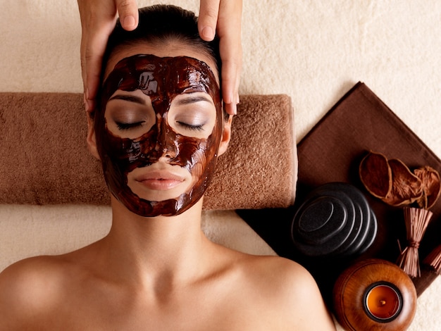 Foto gratuita massaggio termale per giovane donna con maschera facciale sul viso - al chiuso