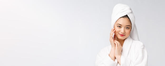 Bellezza cura della pelle spa donna asiatica asciugando i capelli con un asciugamano sulla testa dopo il trattamento doccia bella ragazza multirazziale toccando la pelle morbida