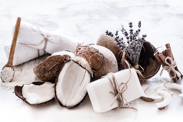 Spa still life of organic cosmetics with coconuts on a light wooden background, body care concept