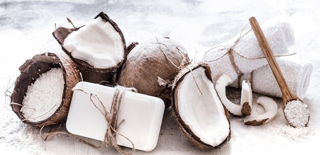 Spa still life of organic cosmetics with coconuts on a light wooden background, body care concept