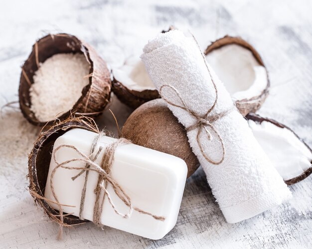 Spa still life of organic cosmetics with coconuts on a light wooden background, body care concept