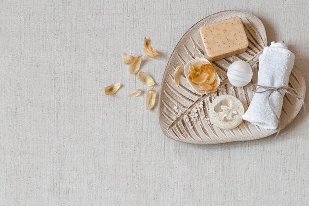 Spa still life with bath accessories for body care among flower petals top view. Health and hygiene concept.