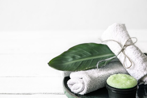 Spa still life with organic skincare, natural leaf and towels. The concept of beauty and organic cosmetics.