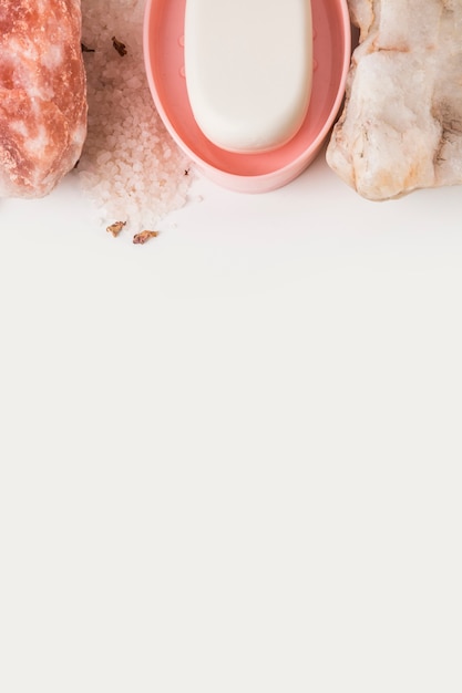 Free photo spa stone; himalayan pink rock salt and soap on white background