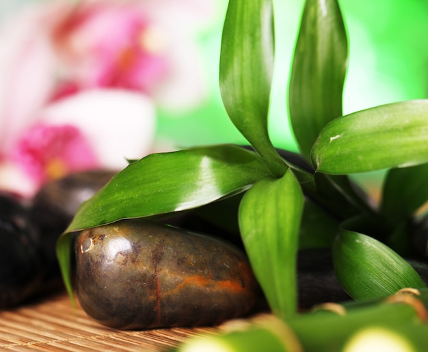 Spa and wellness, massage stones and flowers on wooden tablecloth