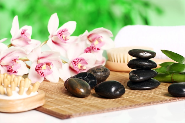 Spa and wellness, massage stones and flowers on wooden tablecloth