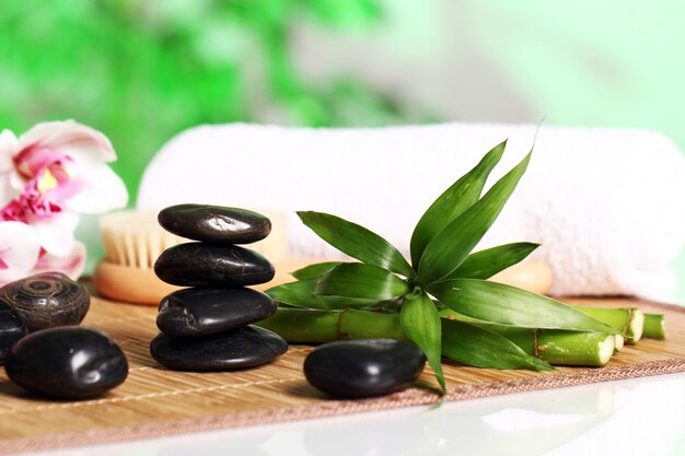 Spa and wellness, massage stones and flowers on wooden tablecloth