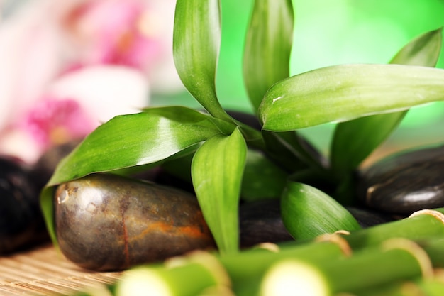 Spa and wellness, massage stones and flowers on wooden tablecloth