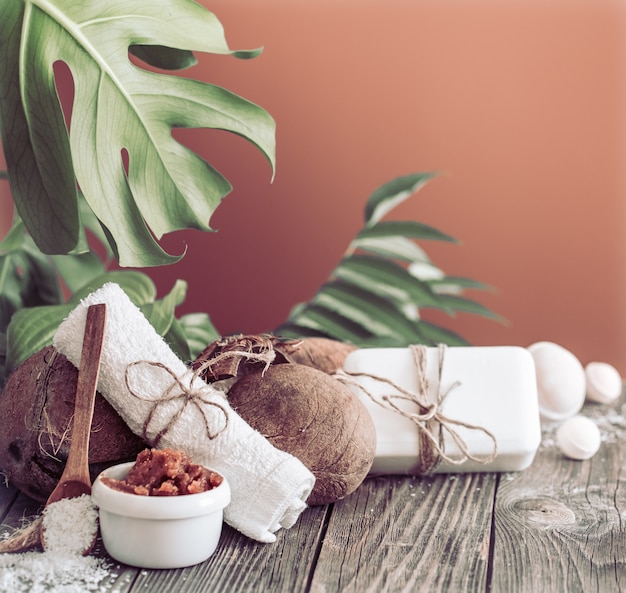 Spa and wellness setting with flowers and towels. Bright composition on brown table with tropical flowers. Dayspa nature products with coconut