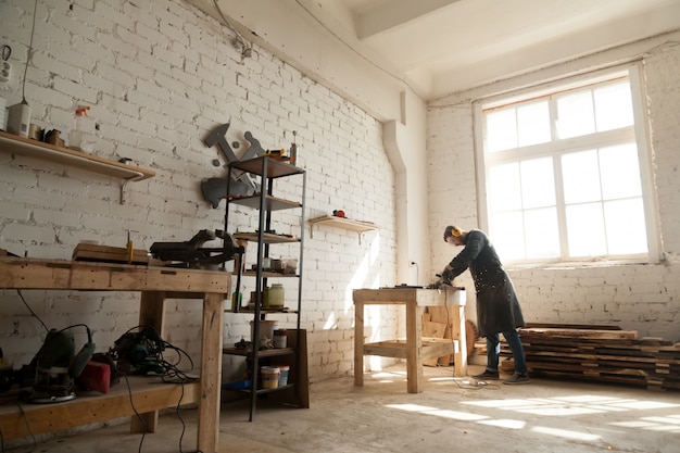 Spacious workshop interior with handyman working with power tools equipment