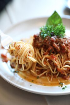 Спагетти болоньезе с фаршем из говядины и томатным соусом, украшенные сыром пармезан и базиликом, итальянская еда