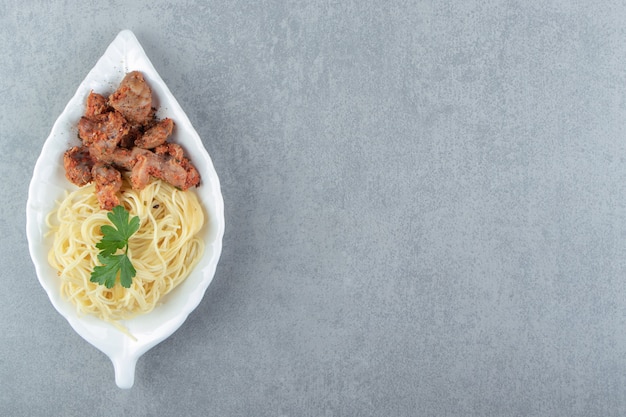 葉の形をしたプレートにスパゲッティと鶏肉のマリネ。