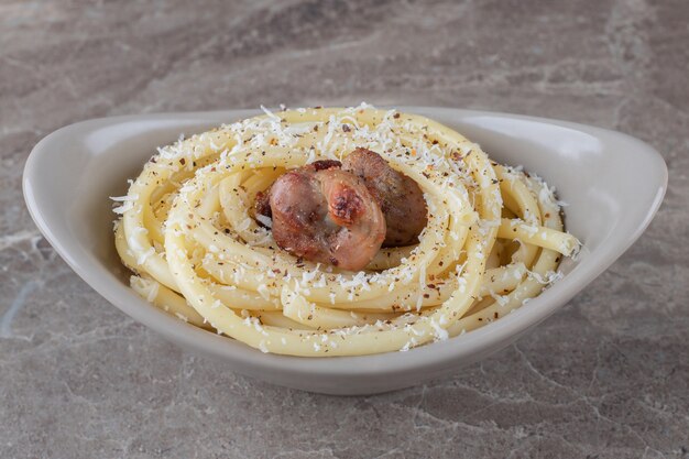 Spaghetti and meat on the bowl , on the marble surface.