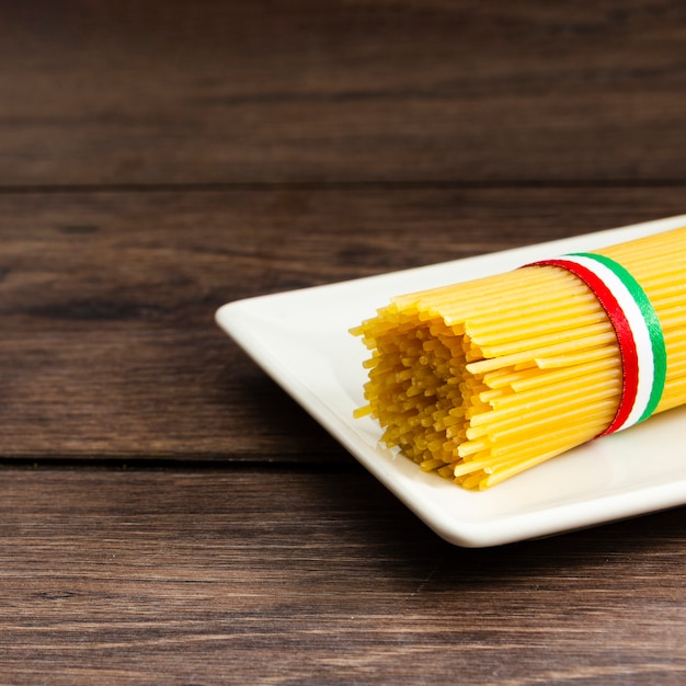 Бесплатное фото Спагетти на тарелке с деревянным хлебом
