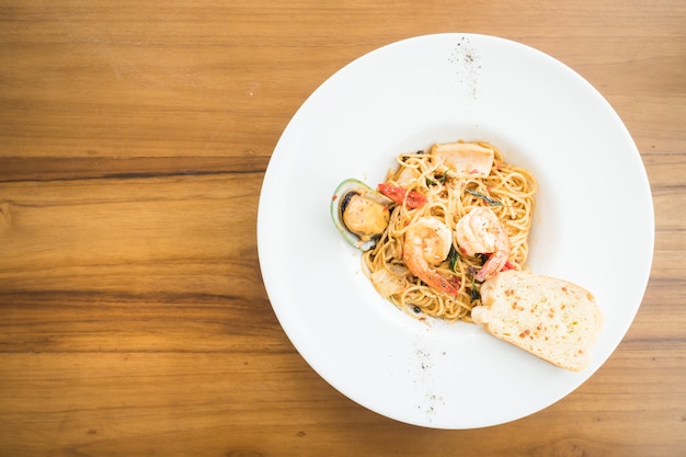 Морепродукты спагетти в белой тарелке