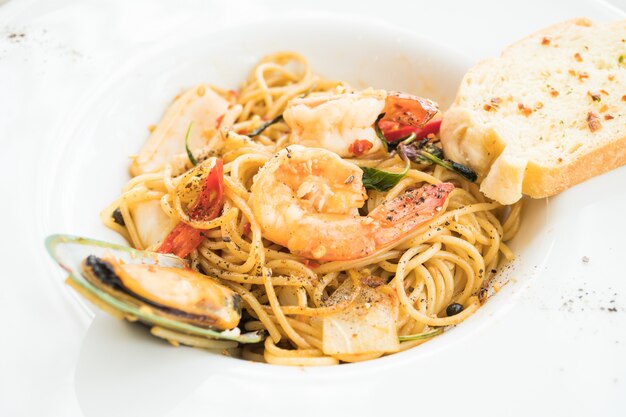 Морепродукты спагетти в белой тарелке