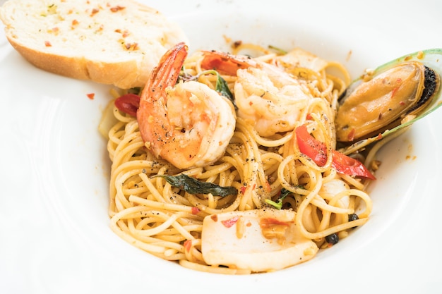 Спагетти из морепродуктов в белой тарелке