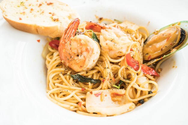 Спагетти из морепродуктов в белой тарелке