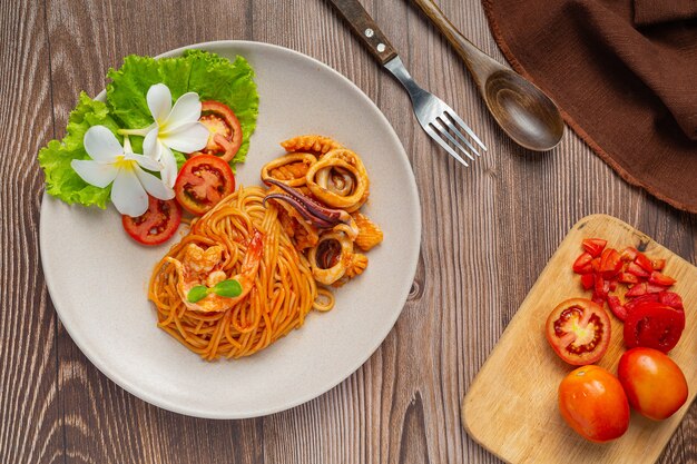 Free photo spaghetti seafood with tomato sauce decorated with beautiful ingredients.