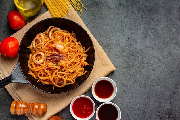 Spaghetti ai frutti di mare con salsa di pomodoro decorati con ingredienti meravigliosi.