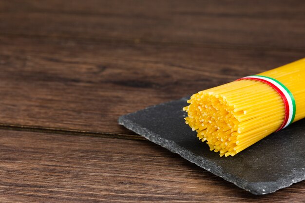 Spaghetti on slate with wooden background