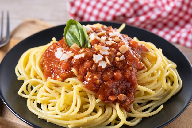 Spaghetti with bolognese sauce on wooden table