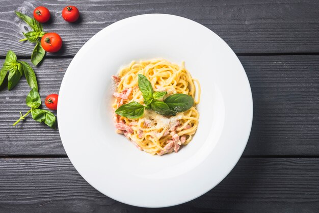 Spaghetti with cheese and basil on a plate