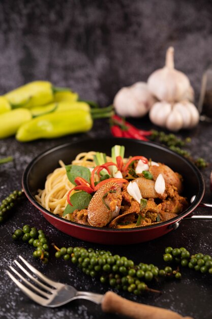 Spaghetti with Clams in a Black Plate with Chilies Fresh garlic and pepper.