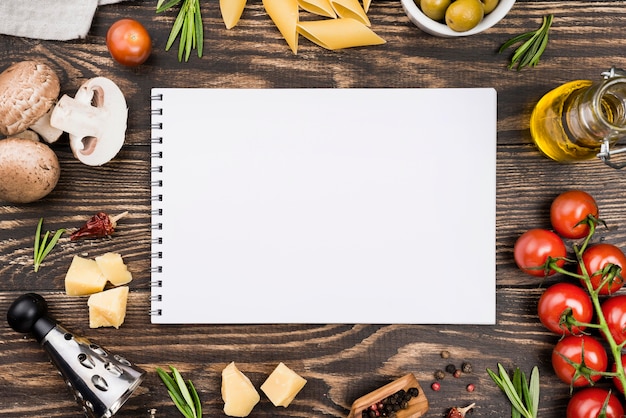 Free photo spaghetti with olives and vegetables and notebook