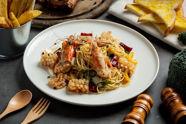 Спагетти с пряными смешанными морепродуктами на темном фоне