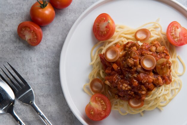 Spaghetti with tomato sauce and sausage in white plate