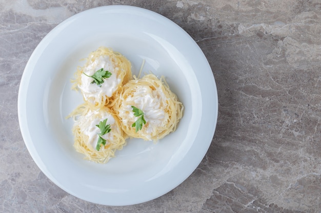 Spaghetti, yogurt and green vegetable on the plate , on the marble.