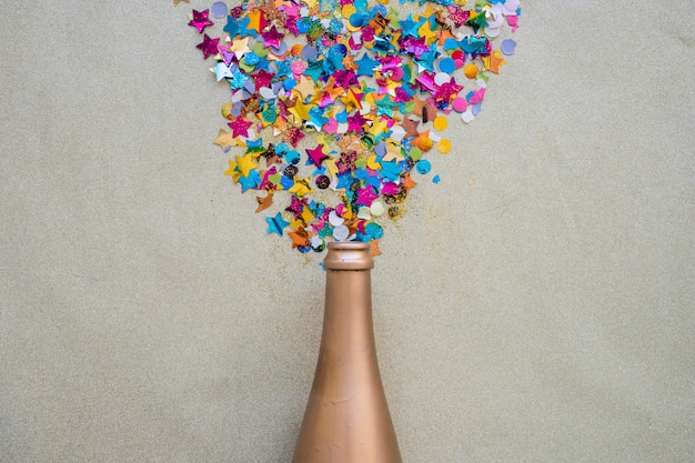 Free photo spangles scattered from bottle on grey table