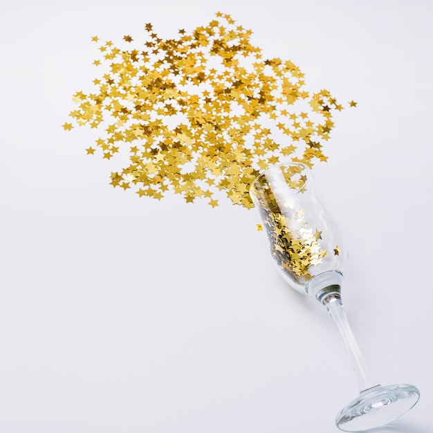 Spangles scattered from glass on table 