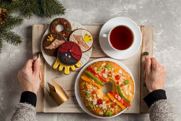 Foto gratuita torta spagnola dell'epifania roscon de reyes e persona che tiene il vassoio