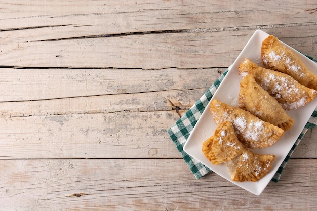 Spanish sweet stuffed pastry filled with angel hair on wooden table