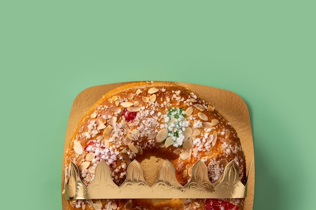 Spanish typical epiphany cake "Roscon de Reyes" on green background