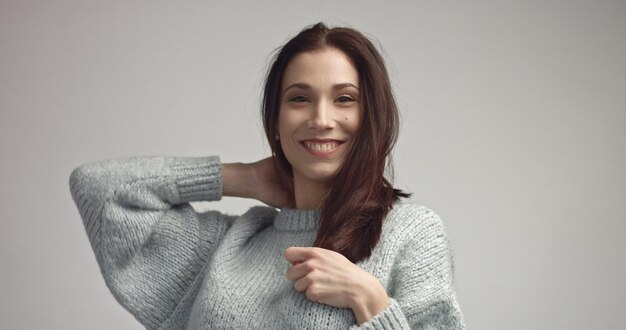 Spanish woman sreaching and touching her straight dark hair ideal skin portrait