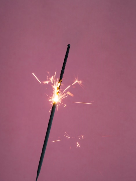 Free photo sparkler burning on pink