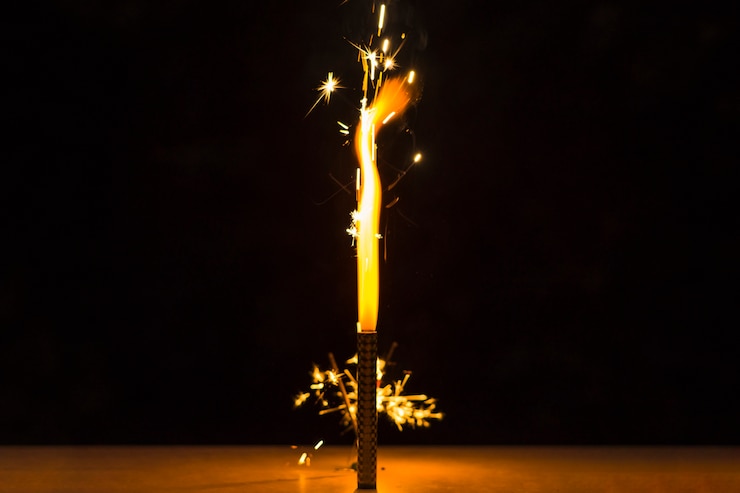 मुफ़्त फोटो sparkler on desk for the independence day celebration against black background