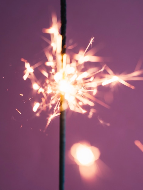 Free photo sparkler stick burning on pink