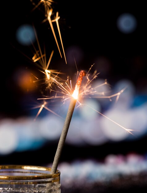 Sparkler in transparent glass with bokeh light background