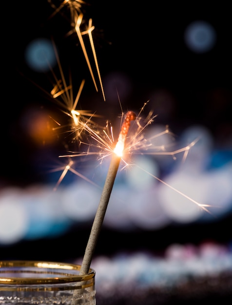 Sparkler in transparent glass with bokeh light background